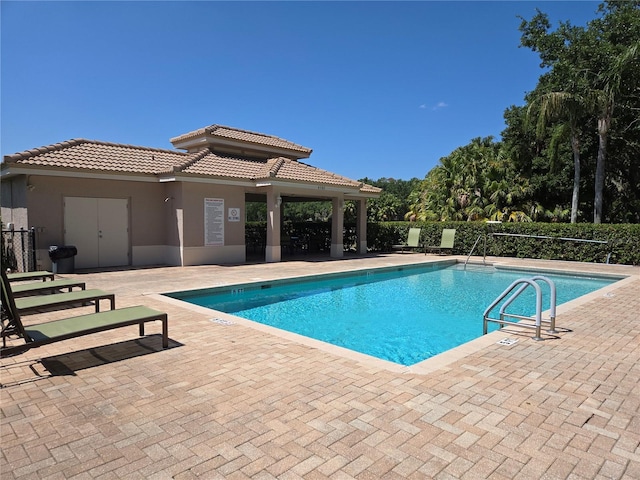pool with fence and a patio