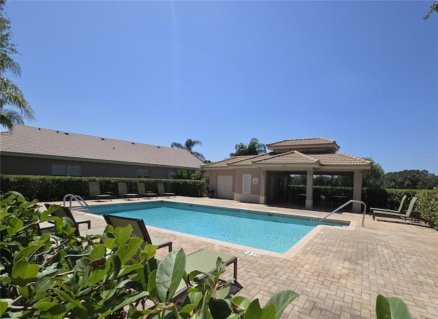 pool featuring fence and a patio area