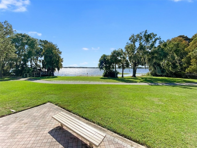 view of community with a lawn and a water view