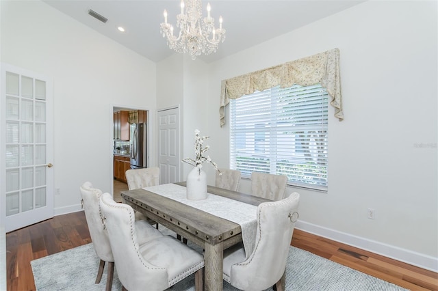 3964 Silk Oak Ln, Palm Harbor, FL 34685 - dining space featuring a chandelier, wood finished floors, baseboards, and a high ceiling