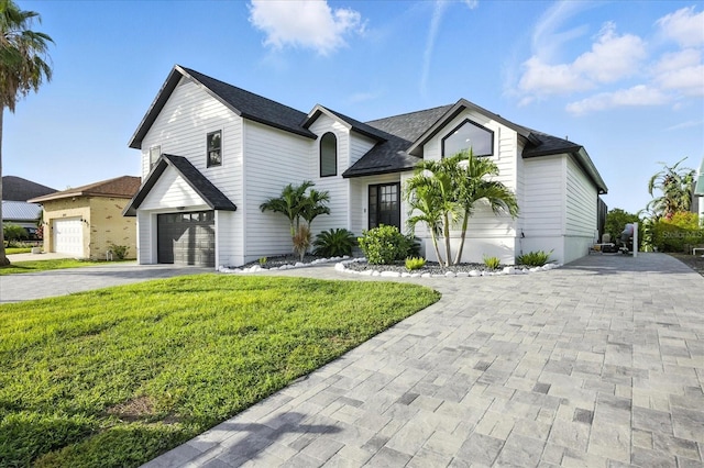 6627 Dolphin Cove Dr, Apollo Beach, FL 33572 - view of front of property featuring driveway, a front lawn, a garage, and roof with shingles