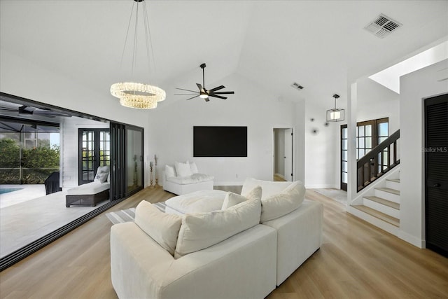 6627 Dolphin Cove Dr, Apollo Beach, FL 33572 - living room with a chandelier, wood finished floors, ceiling fan, high vaulted ceiling, and stairway