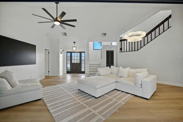 6627 Dolphin Cove Dr, Apollo Beach, FL 33572 - living area with stairway, light wood finished floors, a high ceiling, ceiling fan, and a chandelier