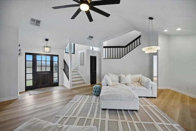 6627 Dolphin Cove Dr, Apollo Beach, FL 33572 - living area with stairway, lofted ceiling, ceiling fan, light wood-type flooring, and a chandelier