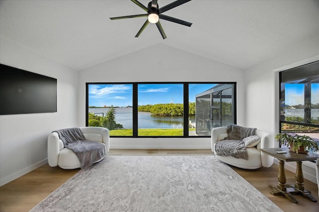 6627 Dolphin Cove Dr, Apollo Beach, FL 33572 - living area with lofted ceiling, a ceiling fan, wood finished floors, and a water view