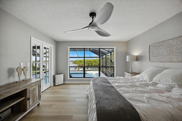 6627 Dolphin Cove Dr, Apollo Beach, FL 33572 - bedroom featuring access to outside, light wood-type flooring, a textured ceiling, and ceiling fan