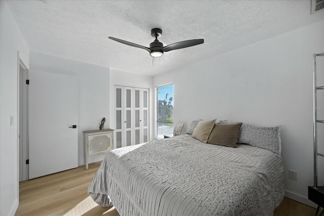 6627 Dolphin Cove Dr, Apollo Beach, FL 33572 - bedroom featuring light wood-type flooring, a ceiling fan, and a textured ceiling