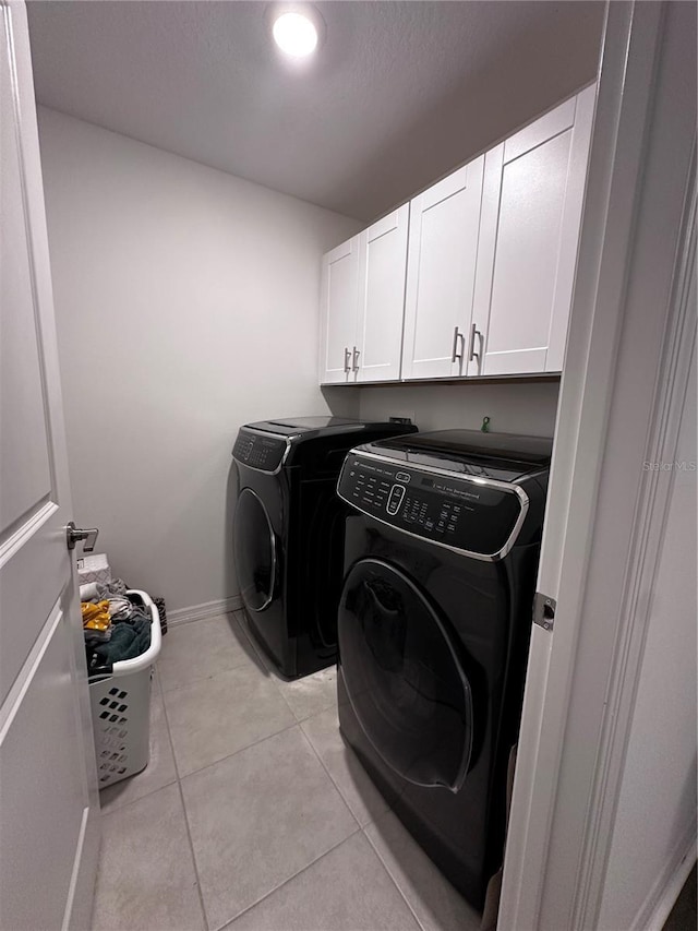6942 Ripple Pond Loop, Zephyrhills, FL 33541 - clothes washing area featuring light tile patterned floors, baseboards, cabinet space, and washing machine and clothes dryer