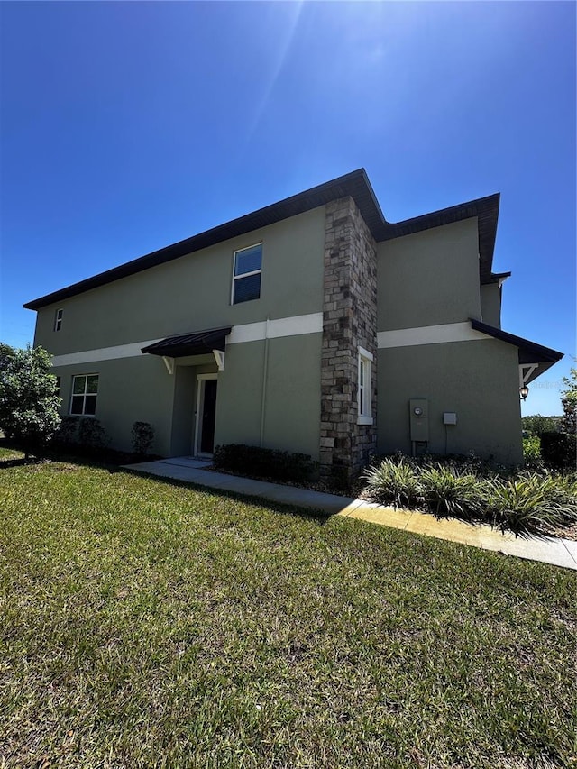 6942 Ripple Pond Loop, Zephyrhills, FL 33541 - rear view of property featuring a lawn and stucco siding