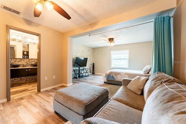 2460 Beacon Groves Blvd, Palm Harbor, FL 34683 - bedroom featuring a textured ceiling, visible vents, light wood finished floors, and ensuite bath