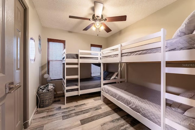 2460 Beacon Groves Blvd, Palm Harbor, FL 34683 - bedroom with baseboards, a ceiling fan, a textured ceiling, and wood finished floors