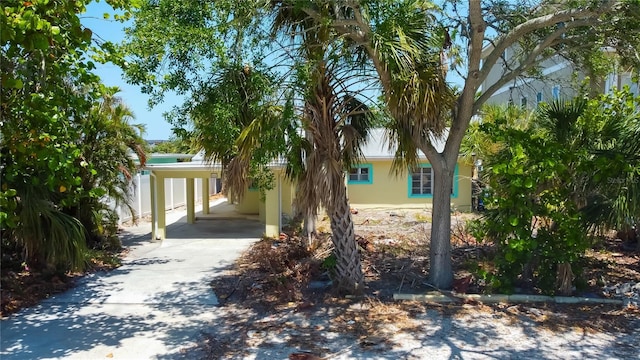 view of front of property featuring concrete driveway, a carport, and stucco siding