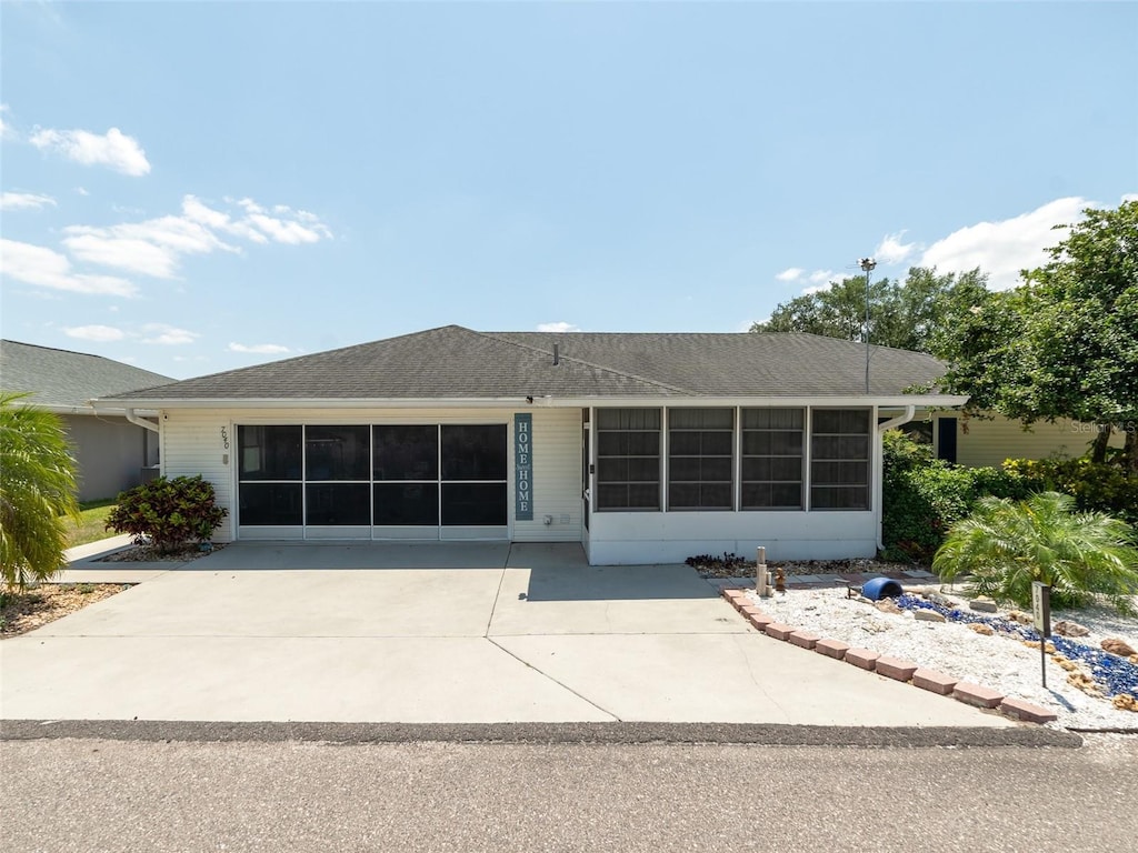 view of front of property with a sunroom and concrete driveway