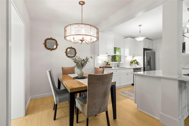 dining area featuring beam ceiling, baseboards, light wood-style flooring, and a notable chandelier