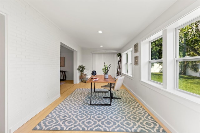 office area with recessed lighting, light wood-style floors, and brick wall