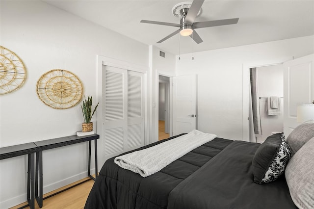 bedroom with connected bathroom, light wood-style floors, a closet, ceiling fan, and visible vents