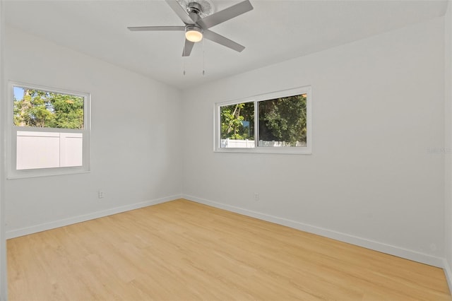 spare room featuring a ceiling fan, wood finished floors, and baseboards