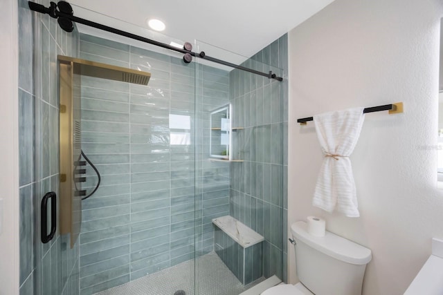 bathroom with a shower stall and toilet