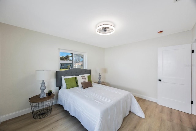 bedroom with baseboards and light wood finished floors