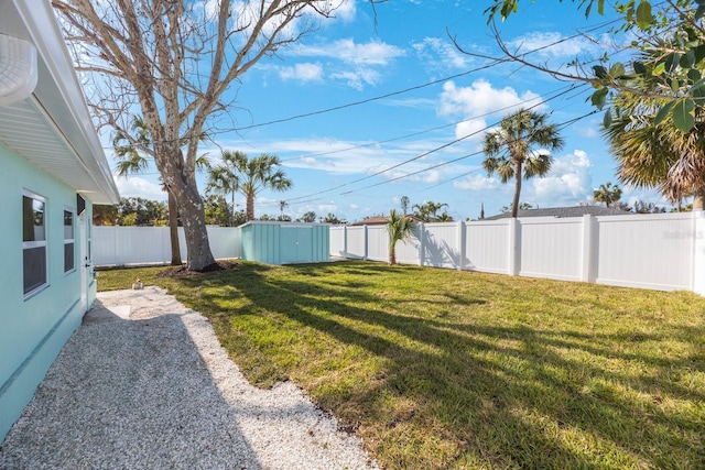 view of yard featuring an outdoor structure, a shed, and a fenced backyard