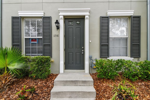 entrance to property with stucco siding