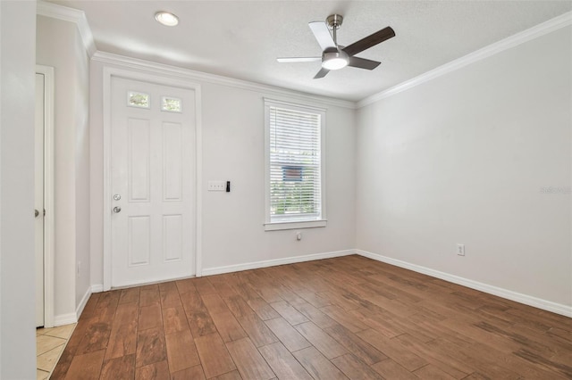 foyer entrance with crown molding, baseboards, ceiling fan, and wood finished floors