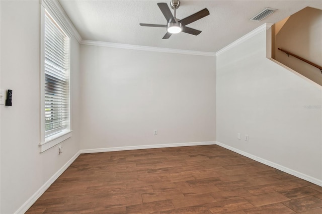 spare room featuring ornamental molding, a ceiling fan, wood finished floors, and visible vents