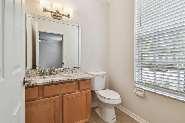 bathroom with vanity, tile patterned flooring, baseboards, and toilet
