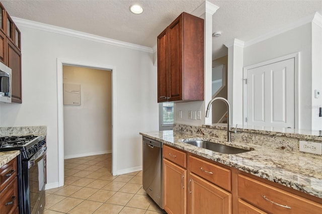 kitchen featuring light stone countertops, a sink, ornamental molding, and stainless steel appliances