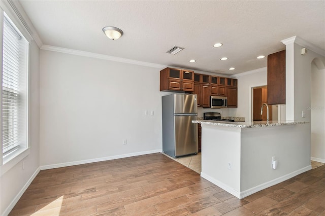 kitchen featuring crown molding, light wood-style floors, stainless steel appliances, recessed lighting, and visible vents