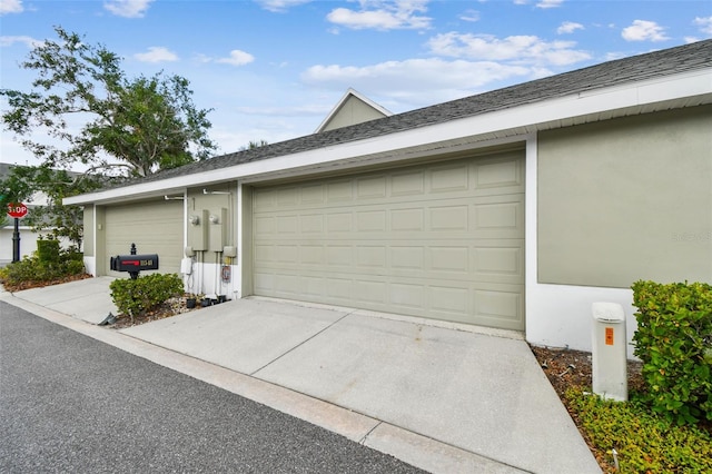 exterior space featuring a garage, stucco siding, and concrete driveway
