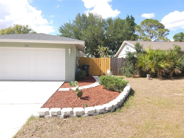 view of home's exterior featuring fence, a garage, driveway, and brick siding