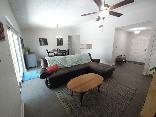 living area with visible vents, baseboards, vaulted ceiling, and ceiling fan with notable chandelier
