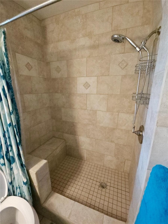 bathroom featuring toilet and a shower stall