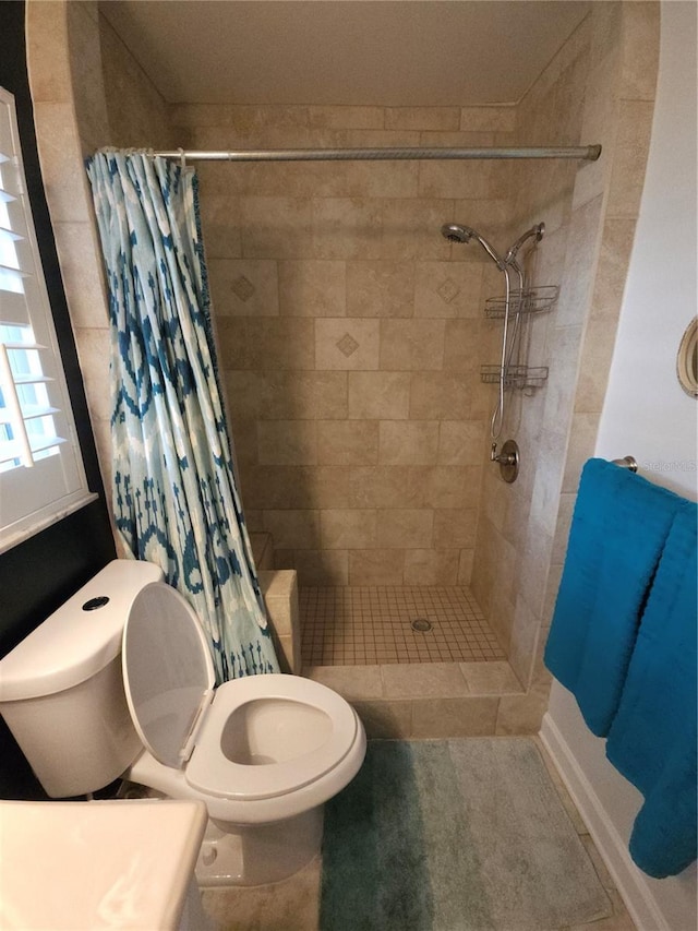 bathroom featuring toilet and tiled shower