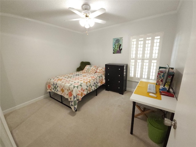 carpeted bedroom featuring baseboards, ornamental molding, and a ceiling fan