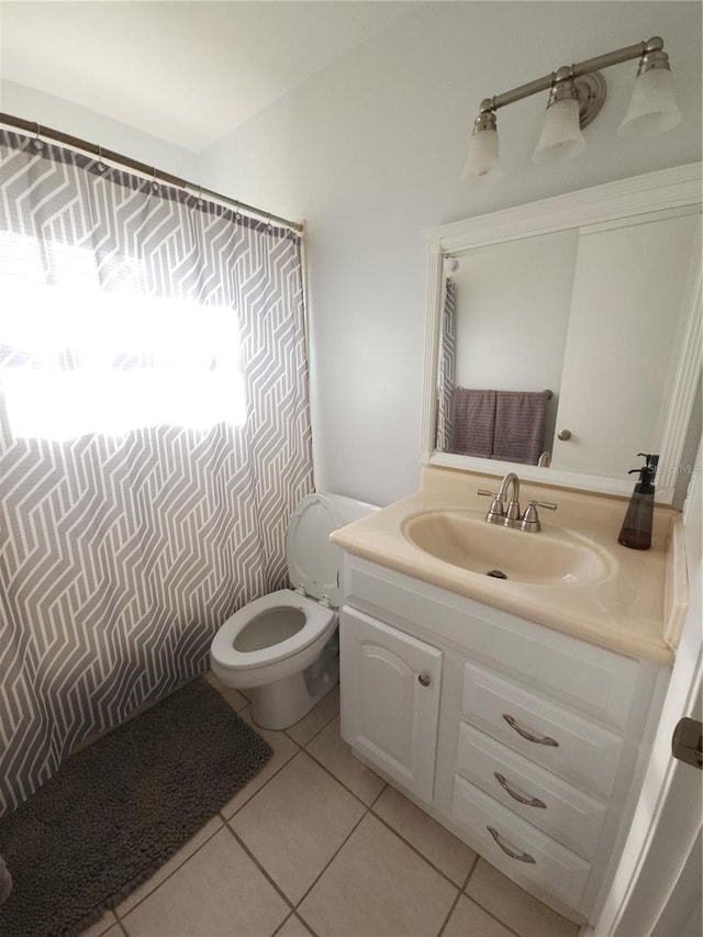bathroom featuring tile patterned flooring, toilet, and vanity