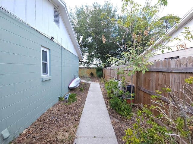 view of property exterior featuring board and batten siding and fence
