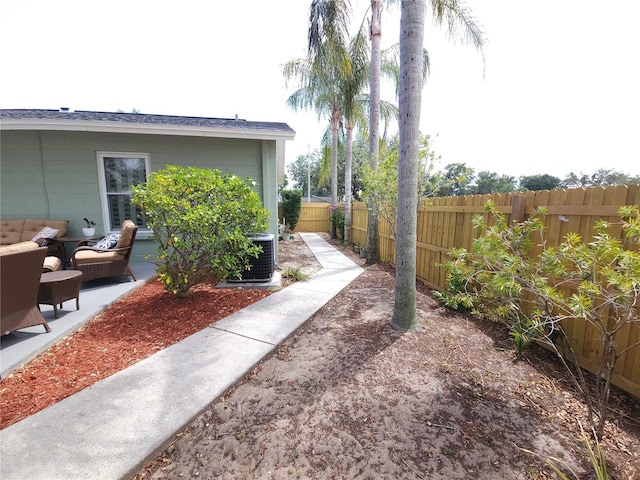 view of yard with a fenced backyard, outdoor lounge area, a patio area, and central AC unit