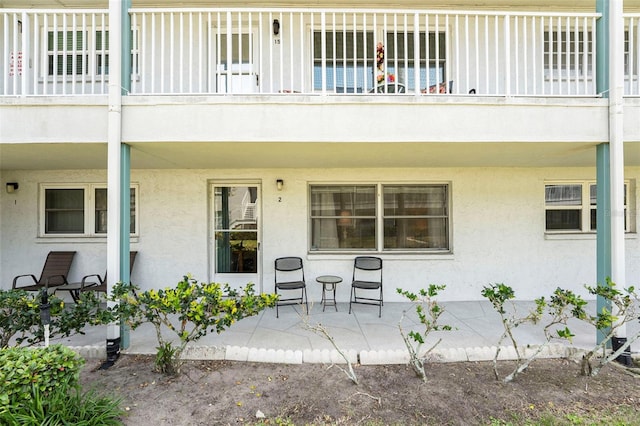 5216 81st St N Unit 2, Saint Petersburg, FL 33709 - view of exterior entry featuring a balcony, stucco siding, and a patio area