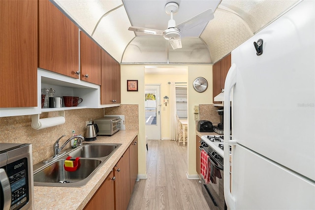 5216 81st St N Unit 2, Saint Petersburg, FL 33709 - kitchen with freestanding refrigerator, gas range, stainless steel microwave, ceiling fan, and light wood-style flooring