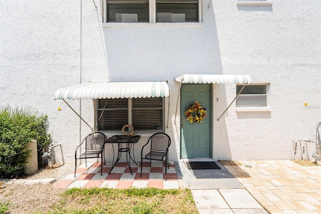 5216 81st St N Unit 2, Saint Petersburg, FL 33709 - view of exterior entry featuring stucco siding and a patio area