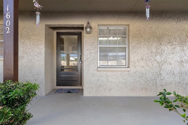 view of exterior entry featuring stucco siding