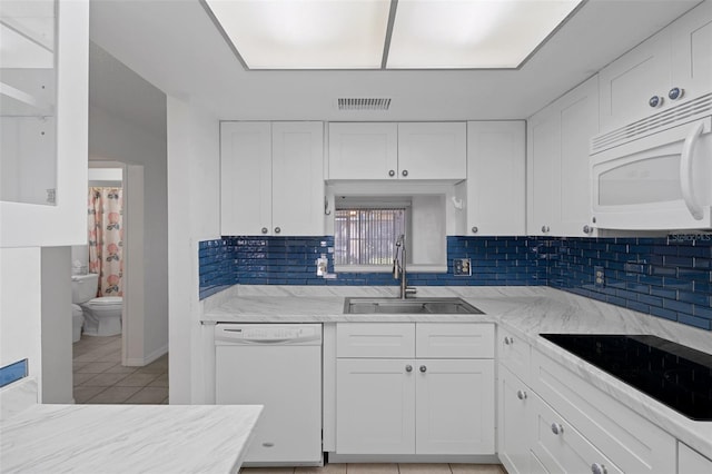 kitchen with a sink, white cabinets, white appliances, and visible vents