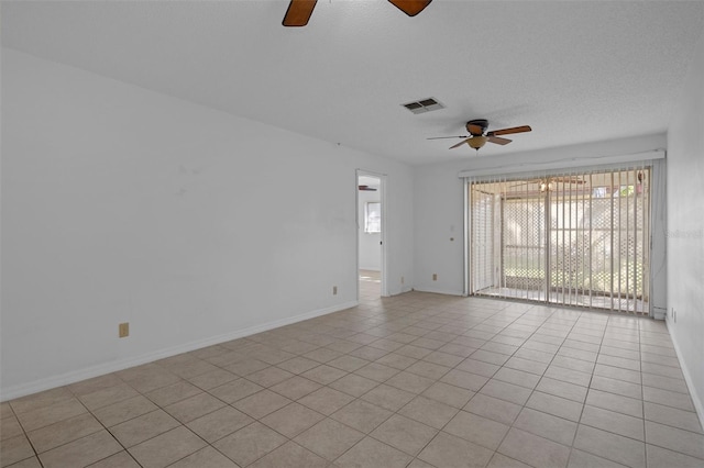 empty room with baseboards, ceiling fan, visible vents, and light tile patterned floors