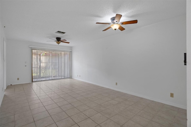 empty room with light tile patterned flooring, a textured ceiling, a ceiling fan, baseboards, and visible vents