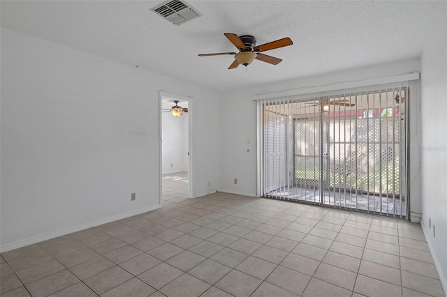 spare room with ceiling fan, a textured ceiling, visible vents, baseboards, and light tile patterned flooring