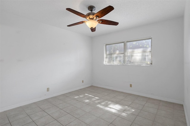 spare room featuring light tile patterned floors, baseboards, and a ceiling fan
