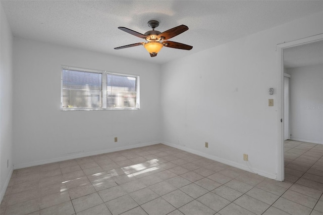 unfurnished room with light tile patterned floors, ceiling fan, and a textured ceiling