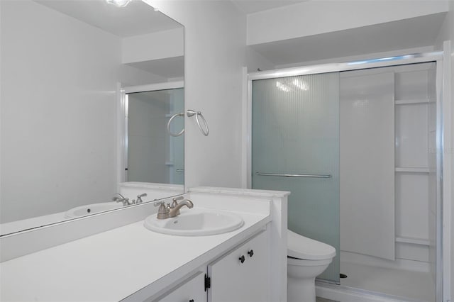 bathroom featuring vanity, a shower stall, and toilet